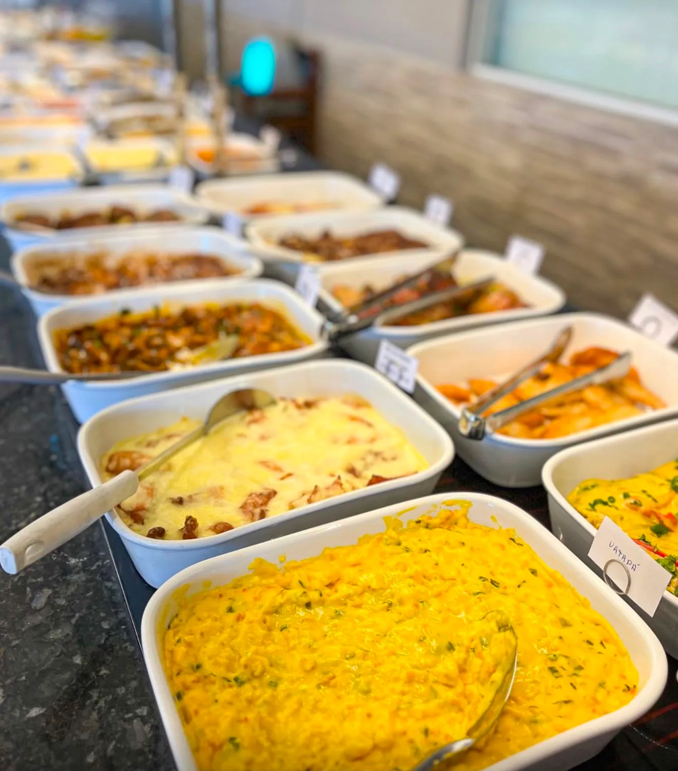 Balcão do self-service com travessas de comida